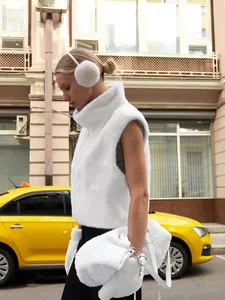 Detail view of a stylish white faux fur vest featuring a high neck and plush texture.