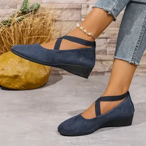 Primo piano di scarpe con zeppa in pelle scamosciata blu navy con cinturini