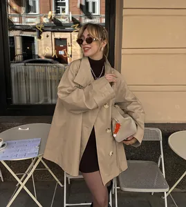 Stylish beige mid-length loose trench coat for women in an autumn cafe street setting.