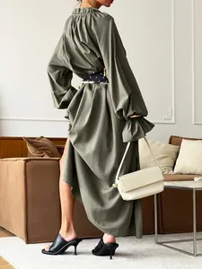 Back view of a French design olive green linen dress with waist tie and slit detail.