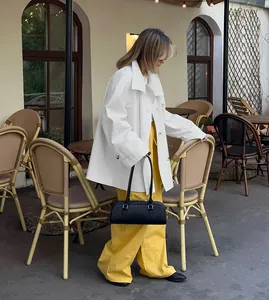 Stylish white mid-length trench coat for women paired with vibrant yellow wide-leg pants
