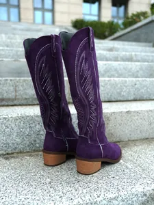 Detail view showing the back of purple suede knight boots with white embroidery and chunky heels