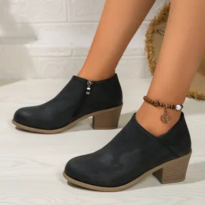 Detailed side view of black chunky heel ankle boots with elegant round toe design
