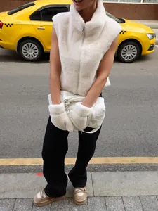 Detailed street view of a plush white faux mink fur vest with high neck zipper