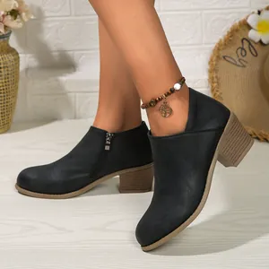 Side view of elegant black chunky heel ankle boots with matte finish and zip detail