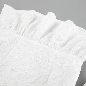 Vista dettagliata della trama del tessuto jacquard bianco su camicia con maniche a sbuffo