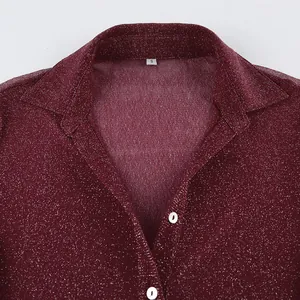 Close-up of maroon glitter long sleeve shirt showing collar detail and reflective fabric texture.