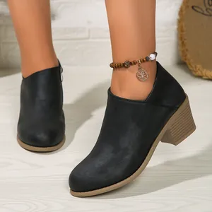 Detailed view of women's black mid-heel ankle boots with stylish round toe design