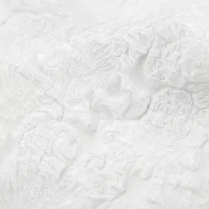 Dettaglio macro di tessuto jacquard bianco a rilievo con trama floreale complessa