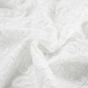 Dettaglio in primo piano del tessuto jacquard bianco per camicia a sbuffo.