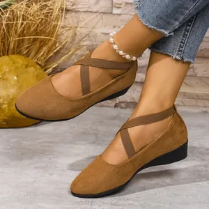 Dettaglio ballerine marroni in pelle scamosciata con elastici incrociati e zeppa