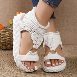 Detailed view of white platform sandals featuring knitted straps and a metal ring detail
