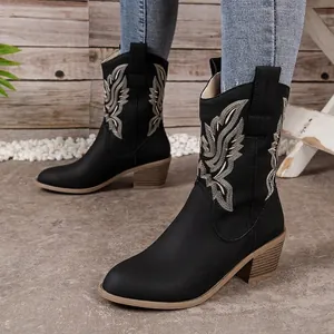 Detailed side view of black western cowboy boots with white embroidery and chunky heel