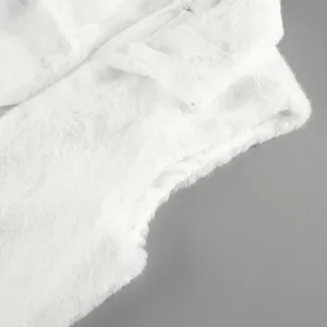 Close-up detail of white faux fur vest showing soft plush texture and high collar.