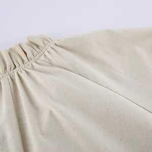Close-up detail of high-quality ruffled stitching on a French style beige linen dress