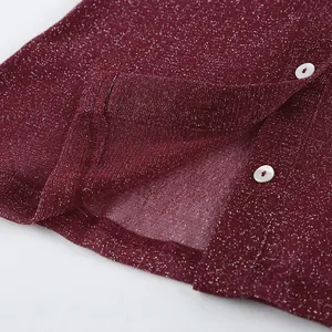 Close-up of burgundy shimmer fabric with white button details on a women's cardigan