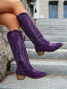 Purple suede mid-calf boots with vintage embroidery and chunky heels worn outdoors