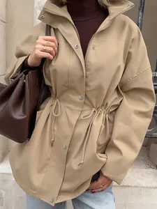 Gros plan d'une veste coupe-vent kaki pour femme avec taille à cordon et boutons-pression