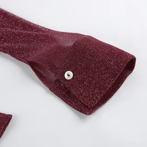 Close-up detail showing the metallic glitter fabric and white button of a burgundy shirt