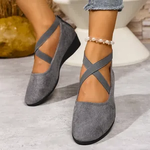 Vista dettagliata di scarpe con zeppa in pelle scamosciata grigia e cinturini elastici