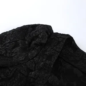 Vista macro della trama del tessuto jacquard floreale 3D nero su una camicia vintage