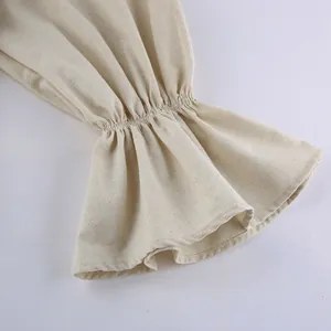 Detail of flared linen sleeve cuff with elastic gathering on beige French dress
