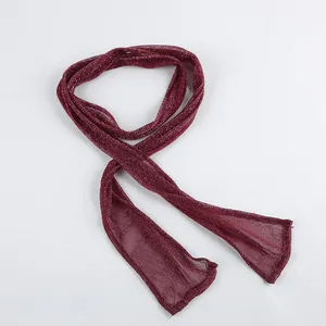 Macro view of elegant deep red shimmering thin neck scarf with reflective glitter finish