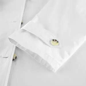 Close-up detail of white trench coat sleeve cuff with marble pattern resin button