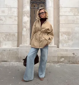Veste barn beige stylée pour femme avec taille à cordon et jean large tendance.