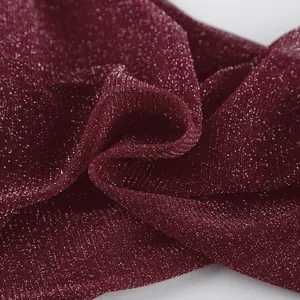 Close-up detail of burgundy sparkle fabric showing fine woven texture and glitter