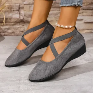 Vista dettagliata di scarpe con zeppa in pelle scamosciata grigia con cinturini incrociati