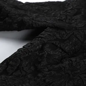 Primo piano della trama del tessuto jacquard nero goffrato su una camicia vintage da donna