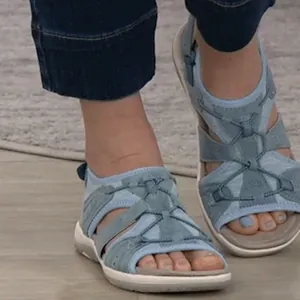 Macro detail view of light blue breathable outdoor flat sandals for women on feet
