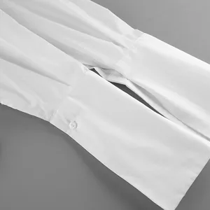 Detailed view of elegant pleated cuffs on a white luxury cotton long-sleeve shirt