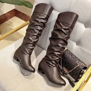 Brown slouchy knee-high boots with round toe and soft leather folds detail