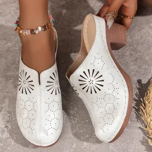 Detailed view of white women's closed-toe mules featuring laser-cut floral patterns