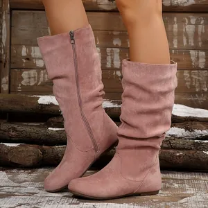 Detail view of pink suede slouchy mid-calf boots showing pleated design and side zipper