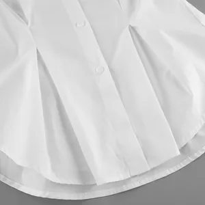 Detailed close-up of white pleated cotton shirt showing fabric texture and buttons