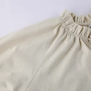 Detailed close-up showing the elegant ruffled neckline of this beige linen French dress
