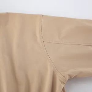 Vue macro de la couture d'épaule et des détails de point sur un trench-coat kaki