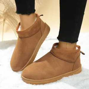 Close-up view of chestnut brown faux fur lined women's snow boots worn on white carpet.
