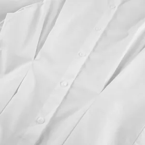 Detailed macro view of white cotton shirt buttons and pleated waist design