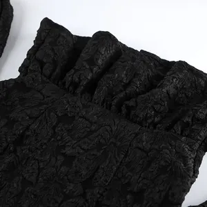 Dettaglio ravvicinato del tessuto jacquard nero di una camicia con maniche a sbuffo