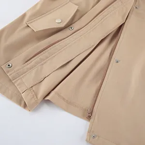 Gros plan sur la fermeture éclair et le bouton-pression d'un trench-coat décontracté kaki