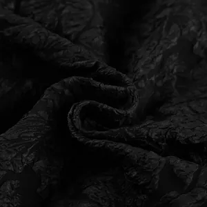 Primo piano di tessuto jacquard nero goffrato con intricate trame floreali 3D.