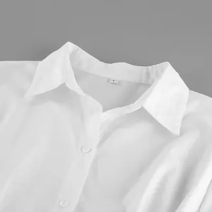 Detailed close-up view of a white cotton shirt collar featuring lapel design and buttons.
