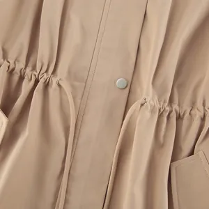 Détail d'un trench-coat kaki pour femme avec une taille à cordon de serrage réglable.
