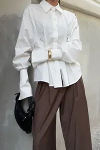 Detail view of a stylish white pleated waist cotton shirt featuring unique elongated cuffs