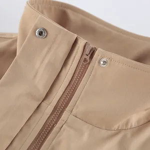 Vue détaillée du col d'un trench-coat kaki pour femme avec fermeture éclair et boutons pressions