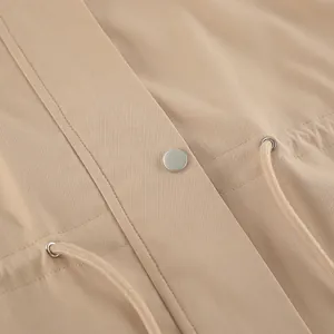 Gros plan détaillé d'un trench-coat kaki avec taille à cordon et ferrures argentées